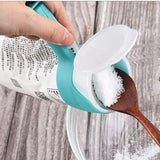 Pouring salt from a clipped bag onto a wooden spoon