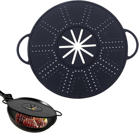 Black silicone anti-spill pot lid with side handles, above a pan of steak