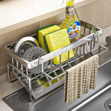 Stainless steel sink caddy holding a sponge, scourer and cloth on a sink edge